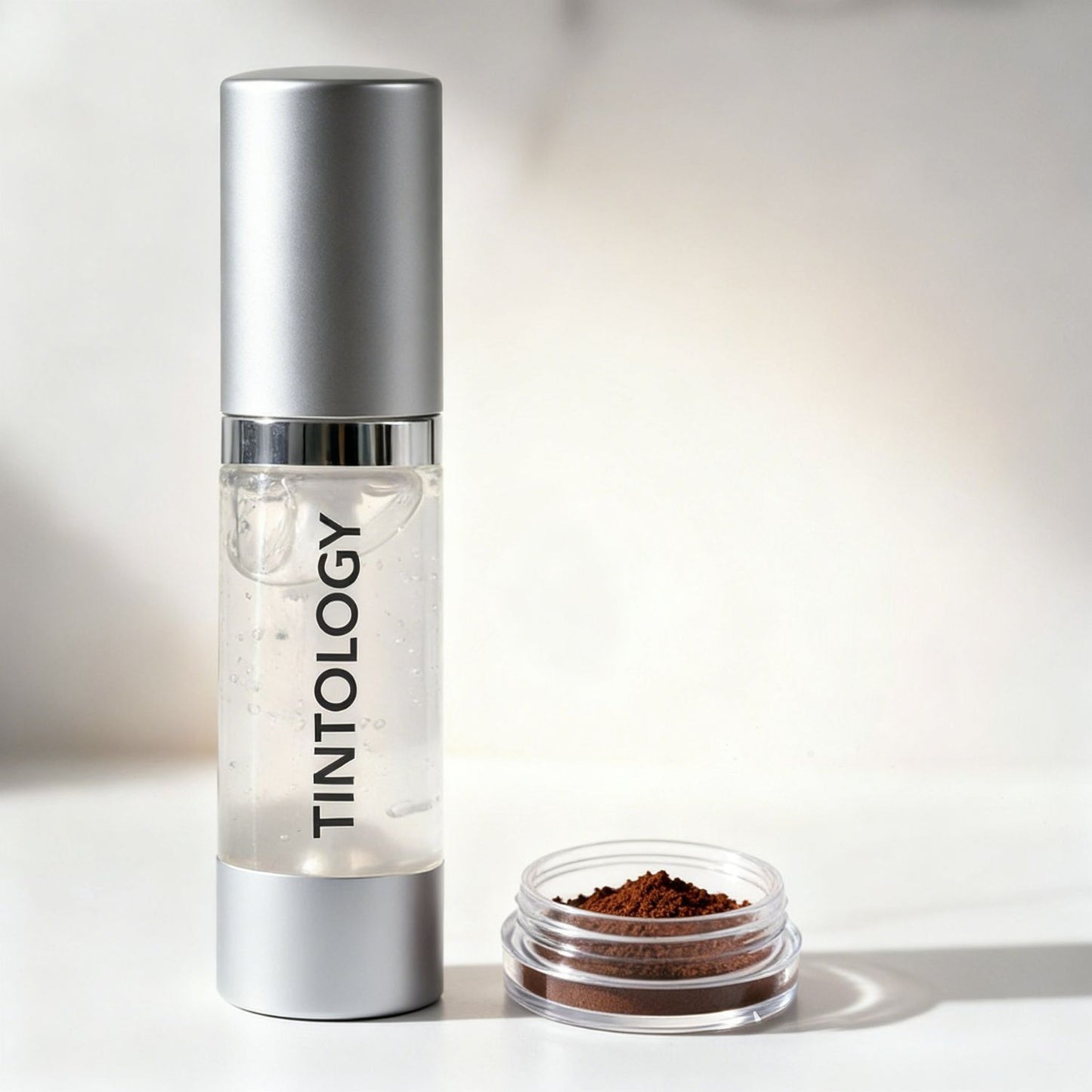 Tintology G2 Activator Gel with a small container of True-Tone Pigment brown powder on a light background